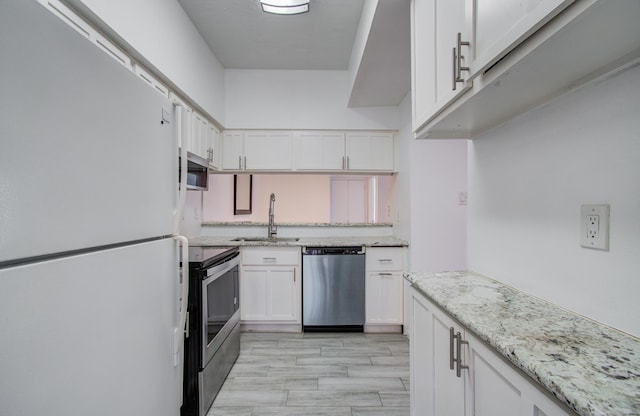 716 Bering Dr Unit 30, Houston, TX 77057 - kitchen with appliances with stainless steel finishes, a sink, white cabinets, and light stone countertops