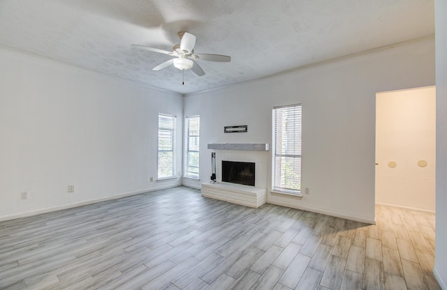 716 Bering Dr Unit 30, Houston, TX 77057 - unfurnished living room featuring light wood-type flooring, a ceiling fan, a brick fireplace, and baseboards