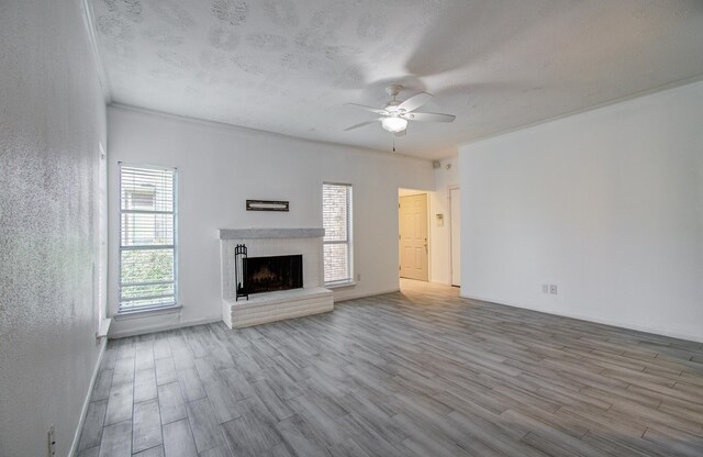716 Bering Dr Unit 30, Houston, TX 77057 - unfurnished living room featuring ceiling fan, wood finished floors, a fireplace, and a textured ceiling