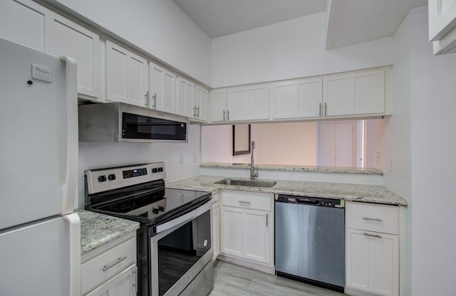 716 Bering Dr Unit 30, Houston, TX 77057 - kitchen with appliances with stainless steel finishes, a sink, white cabinetry, and light stone counters