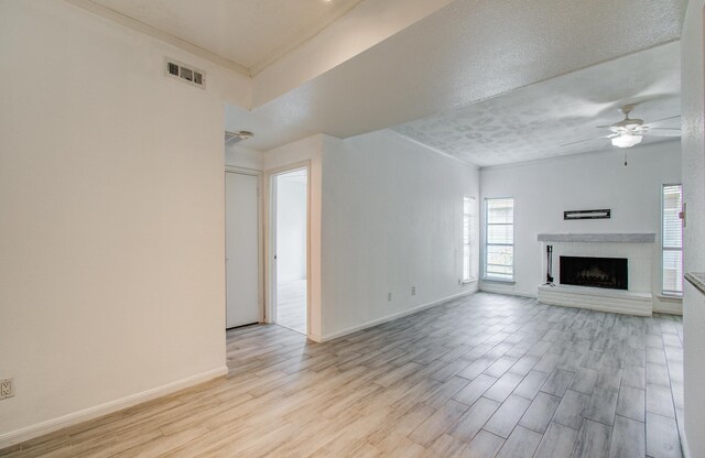 716 Bering Dr Unit 30, Houston, TX 77057 - unfurnished living room with wood finished floors, a ceiling fan, a fireplace, crown molding, and baseboards