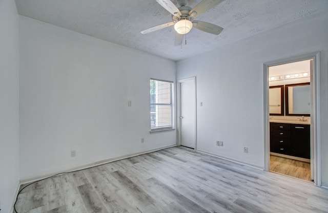 716 Bering Dr Unit 30, Houston, TX 77057 - unfurnished bedroom featuring light wood-style floors, ensuite bathroom, a textured ceiling, a ceiling fan, and a sink