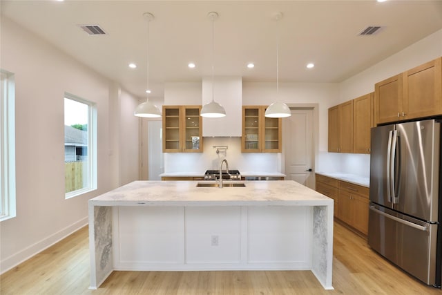 510 E 37th St, Houston, TX 77022 - kitchen with freestanding refrigerator, a sink, brown cabinets, an island with sink, and recessed lighting