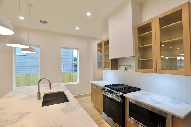 510 E 37th St, Houston, TX 77022 - kitchen with a sink, appliances with stainless steel finishes, light wood-style floors, backsplash, and glass insert cabinets