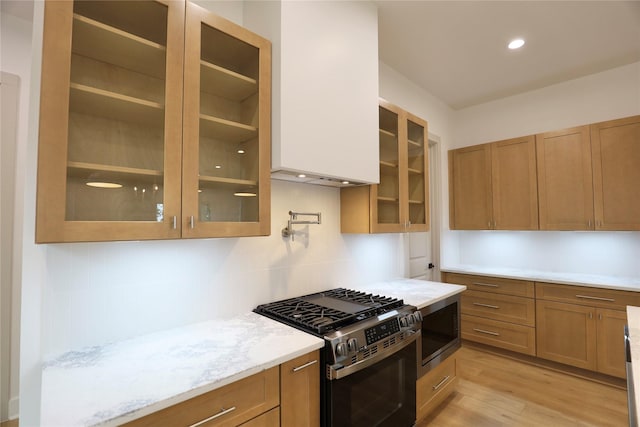 510 E 37th St, Houston, TX 77022 - kitchen featuring gas stove, glass insert cabinets, brown cabinets, light wood-type flooring, and recessed lighting