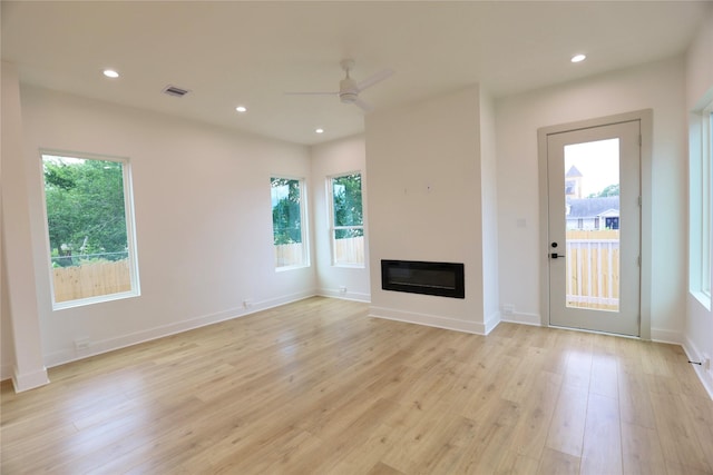 510 E 37th St, Houston, TX 77022 - unfurnished living room featuring a ceiling fan, light wood finished floors, a glass covered fireplace, recessed lighting, and baseboards