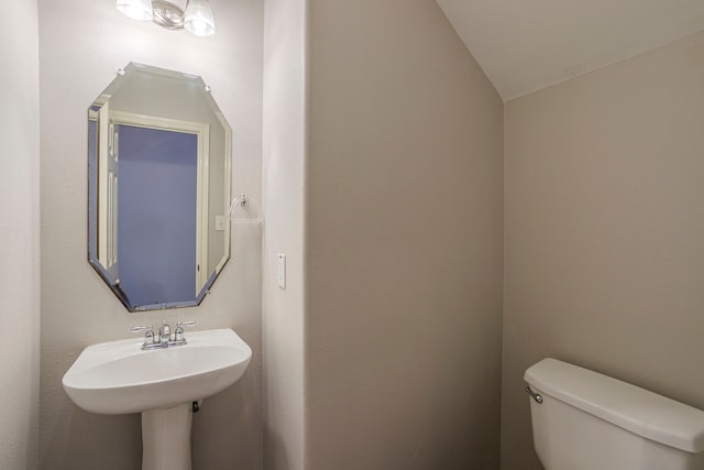 13035 Echo Landing Dr, Houston, TX 77070 - bathroom featuring toilet, vaulted ceiling, and a sink