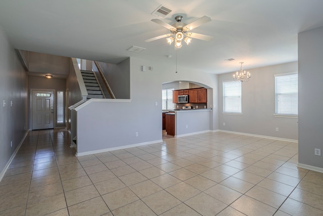 13035 Echo Landing Dr, Houston, TX 77070 - unfurnished living room with light tile patterned floors, a chandelier, a ceiling fan, stairway, and baseboards