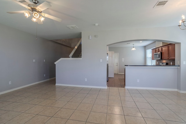 13035 Echo Landing Dr, Houston, TX 77070 - unfurnished living room with arched walkways, a ceiling fan, light tile patterned flooring, and baseboards