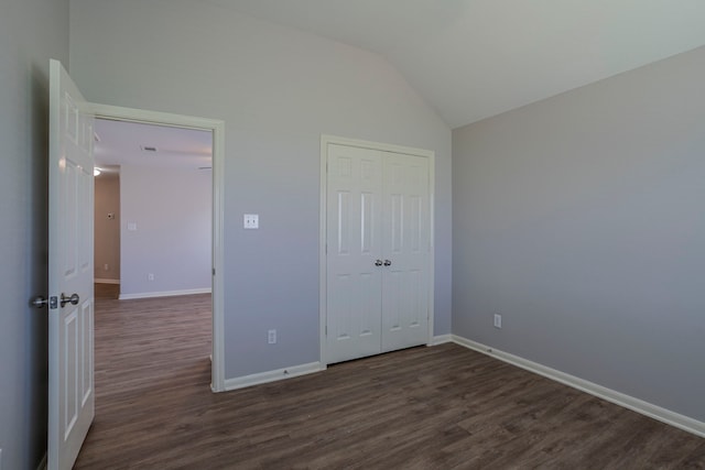13035 Echo Landing Dr, Houston, TX 77070 - unfurnished bedroom featuring dark wood-style flooring, baseboards, lofted ceiling, and a closet