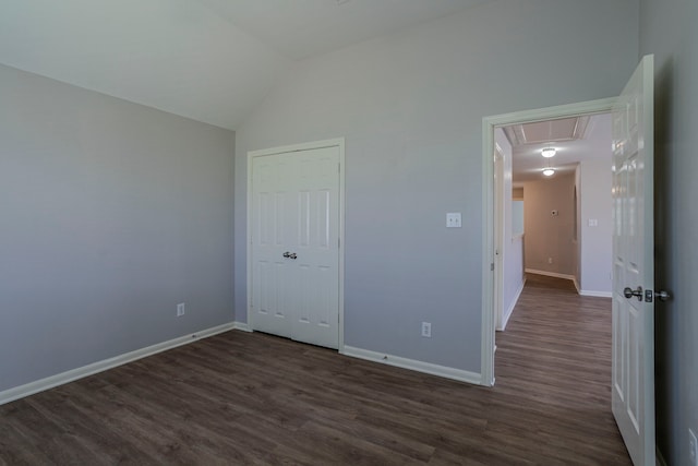 13035 Echo Landing Dr, Houston, TX 77070 - unfurnished bedroom featuring attic access, dark wood finished floors, baseboards, and vaulted ceiling