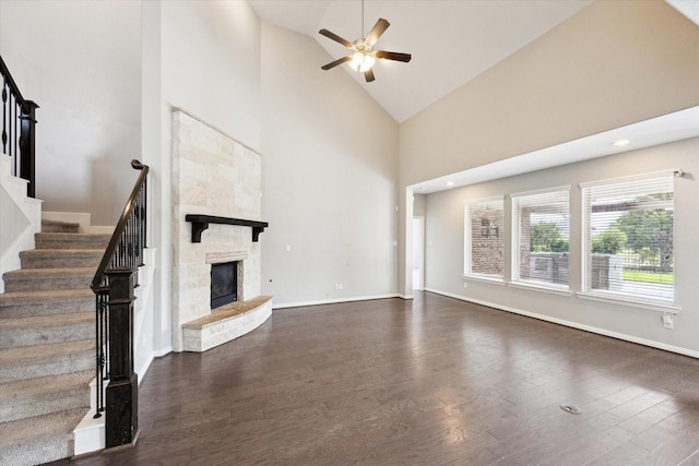 6406 Diamantina Ct, Katy, TX 77493 - unfurnished living room featuring ceiling fan, high vaulted ceiling, dark wood-type flooring, stairs, and a stone fireplace