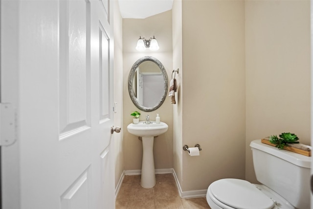 bathroom with toilet, tile patterned flooring, and baseboards
