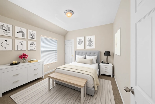 carpeted bedroom with baseboards and lofted ceiling