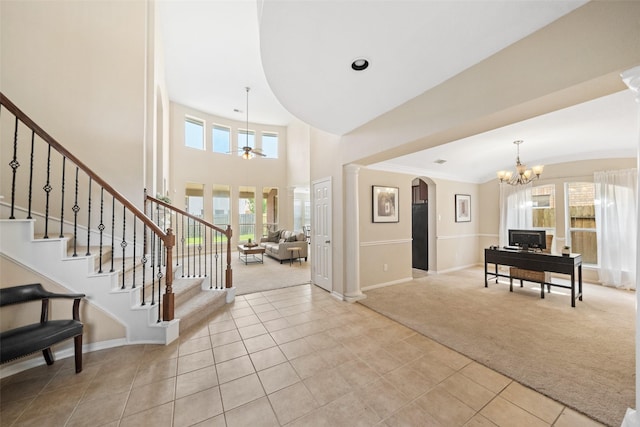 entrance foyer with light colored carpet, light tile patterned floors, a chandelier, stairs, and baseboards