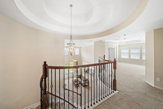 stairs with carpet flooring, a raised ceiling, baseboards, and decorative columns