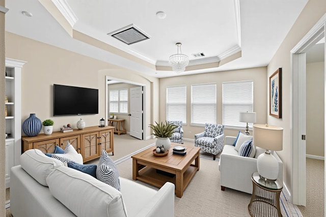 living area featuring a raised ceiling, ornamental molding, light carpet, baseboards, and a chandelier