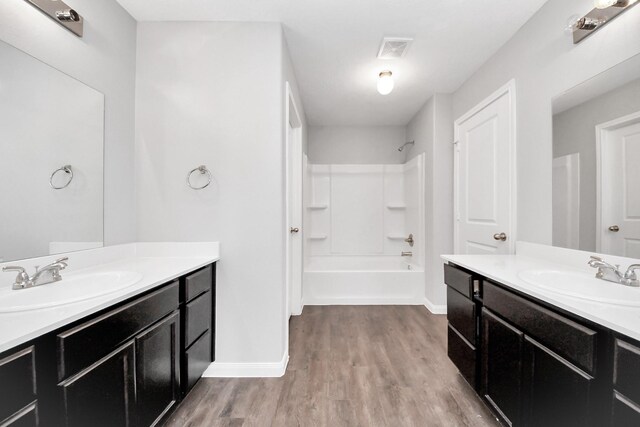 696 Rd 5105, Cleveland, TX 77327 - bathroom with baseboards, wood finished floors, shower / tub combination, and two vanities