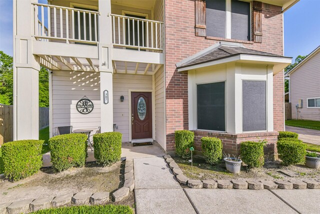 307 Squall Ct, Crosby, TX 77532 - doorway to property with a balcony, brick siding, and covered porch