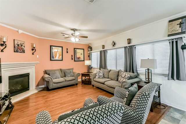 307 Squall Ct, Crosby, TX 77532 - living room with ornamental molding, plenty of natural light, a glass covered fireplace, and wood finished floors