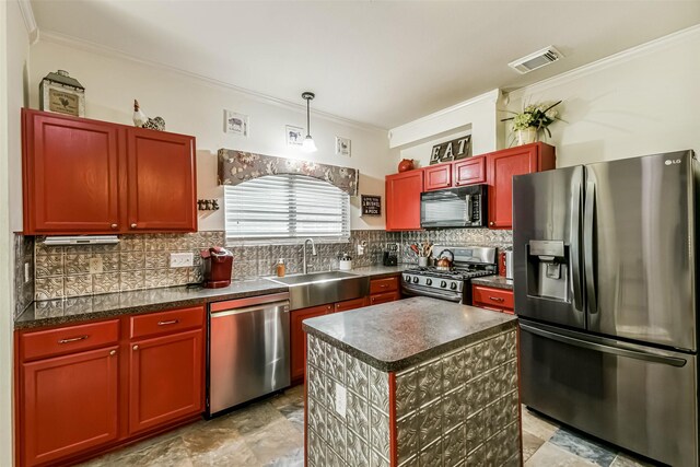 307 Squall Ct, Crosby, TX 77532 - kitchen with stainless steel appliances, ornamental molding, a sink, dark countertops, and reddish brown cabinets