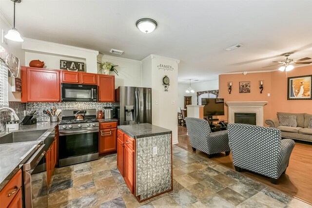 307 Squall Ct, Crosby, TX 77532 - kitchen with appliances with stainless steel finishes, a sink, open floor plan, decorative backsplash, and crown molding