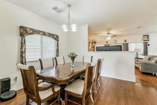 307 Squall Ct, Crosby, TX 77532 - dining area with healthy amount of natural light, a chandelier, hardwood / wood-style flooring, ceiling fan, and crown molding