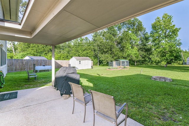 307 Squall Ct, Crosby, TX 77532 - view of patio / terrace featuring an outbuilding, an outdoor fire pit, grilling area, a greenhouse, and a storage shed