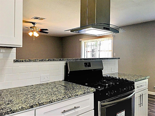 8322 Cabot St, Houston, TX 77078 - kitchen featuring gas stove, extractor fan, white cabinetry, ceiling fan, and decorative backsplash