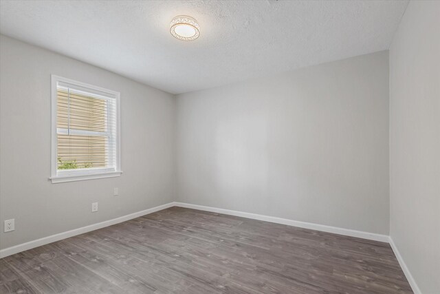 3518 Ball, Galveston, TX 77550 - empty room with wood finished floors, baseboards, and a textured ceiling