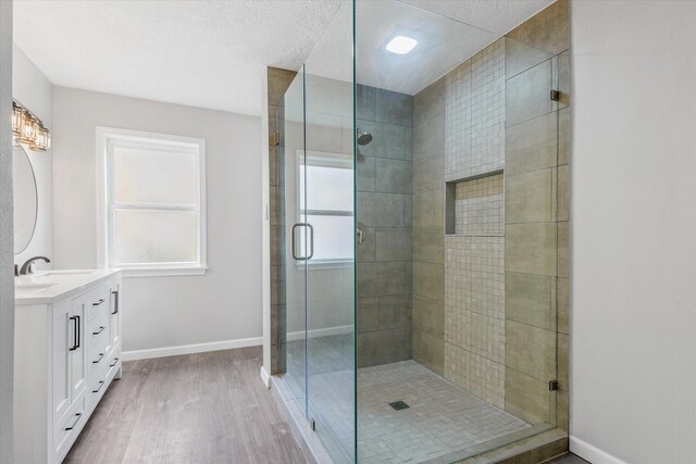 3518 Ball, Galveston, TX 77550 - bathroom featuring baseboards, wood finished floors, a stall shower, and vanity