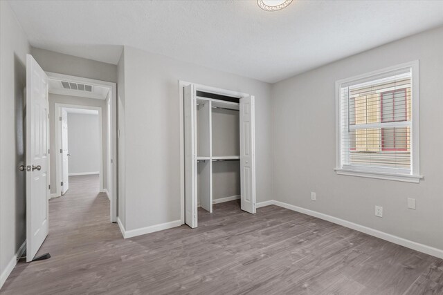 3518 Ball, Galveston, TX 77550 - unfurnished bedroom featuring wood finished floors, baseboards, and a closet