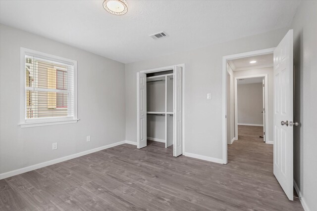 3518 Ball, Galveston, TX 77550 - unfurnished bedroom with wood finished floors, baseboards, and a closet
