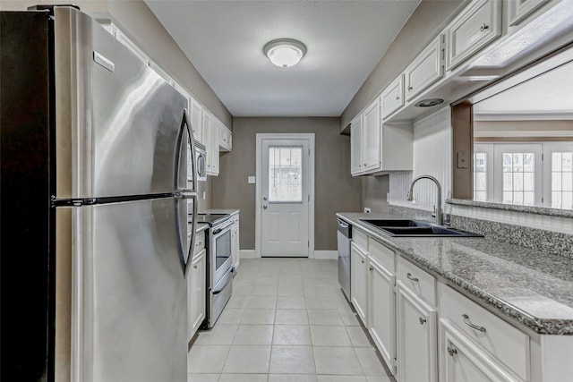 13060 Trail Hollow Dr Unit 3060, Houston, TX 77079 - kitchen with appliances with stainless steel finishes, a sink, baseboards, light tile patterned flooring, and white cabinetry