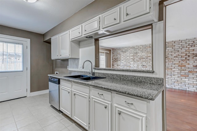 13060 Trail Hollow Dr Unit 3060, Houston, TX 77079 - kitchen featuring a sink, dishwasher, white cabinetry, baseboards, and brick wall