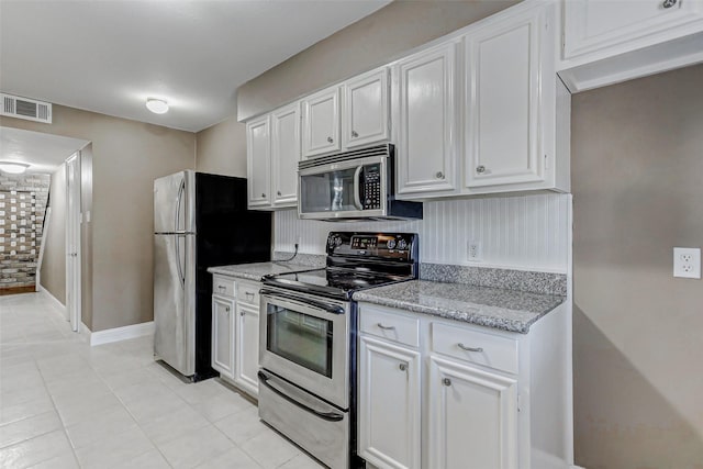 13060 Trail Hollow Dr Unit 3060, Houston, TX 77079 - kitchen with appliances with stainless steel finishes, white cabinetry, light tile patterned flooring, and light stone counters