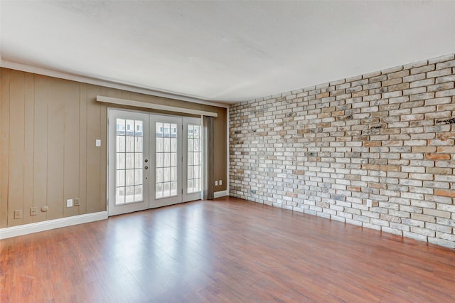 13060 Trail Hollow Dr Unit 3060, Houston, TX 77079 - spare room with wood finished floors, french doors, baseboards, and brick wall