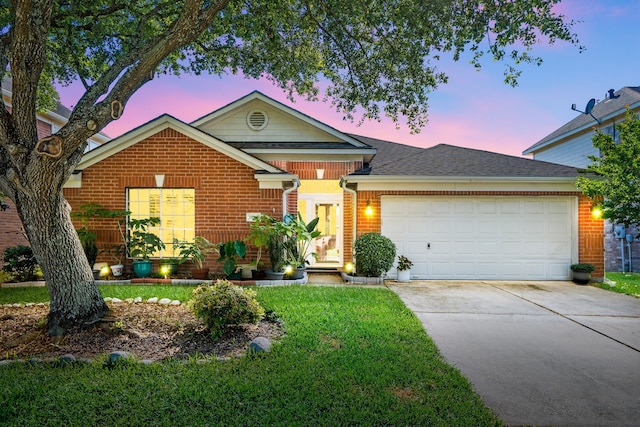 view of front of house with brick siding, an attached garage, driveway, a yard, and a shingled roof