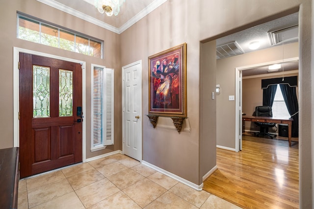 foyer entrance featuring crown molding, baseboards, and light tile patterned floors