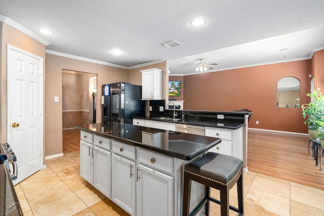 kitchen featuring black fridge, a sink, a peninsula, ceiling fan, and dishwasher