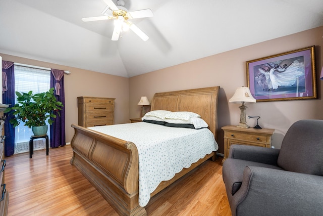 bedroom featuring light wood-type flooring, vaulted ceiling, and ceiling fan