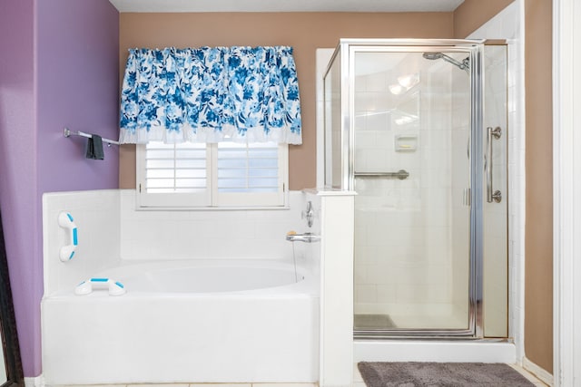 bathroom featuring a stall shower and a bath