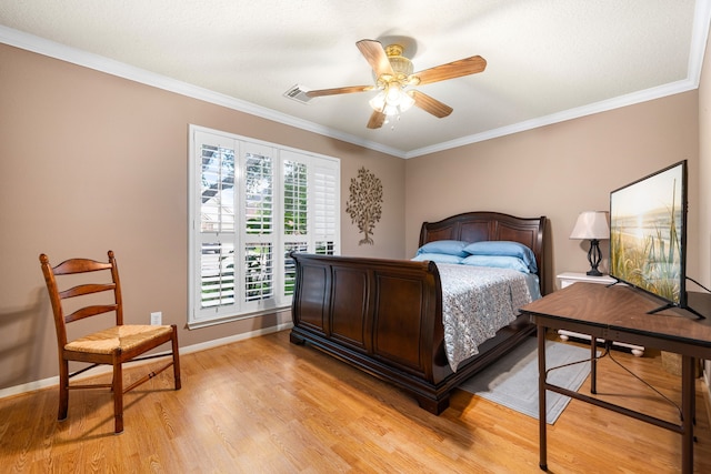 bedroom featuring light wood finished floors, crown molding, baseboards, and a ceiling fan