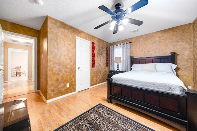 bedroom featuring light wood-style flooring, baseboards, and ceiling fan