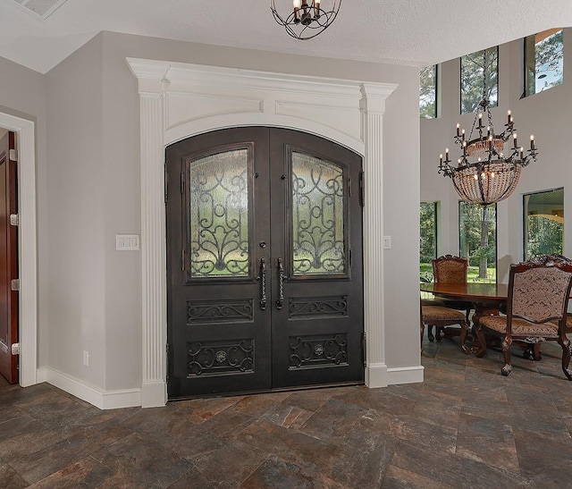280 Sundog Rd, Huntsville, TX 77340 - foyer entrance with a chandelier, french doors, baseboards, and stone tile floors