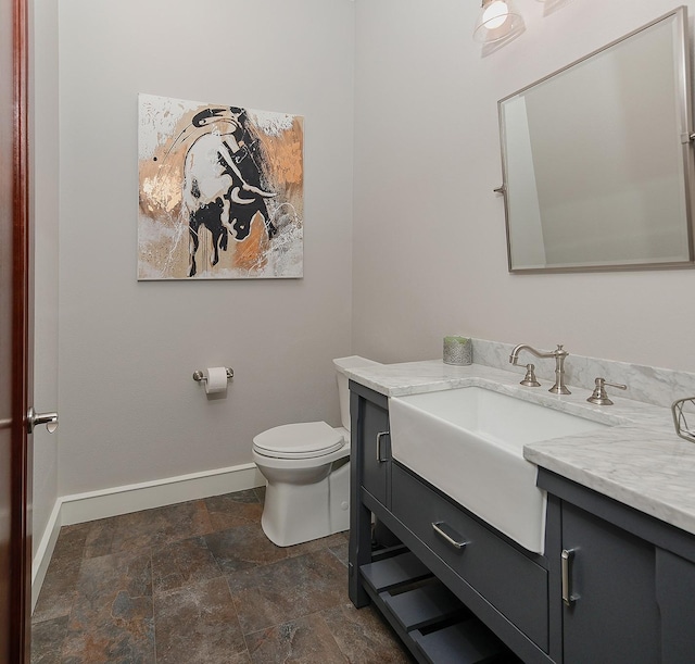 280 Sundog Rd, Huntsville, TX 77340 - bathroom with baseboards, vanity, toilet, and stone finish flooring