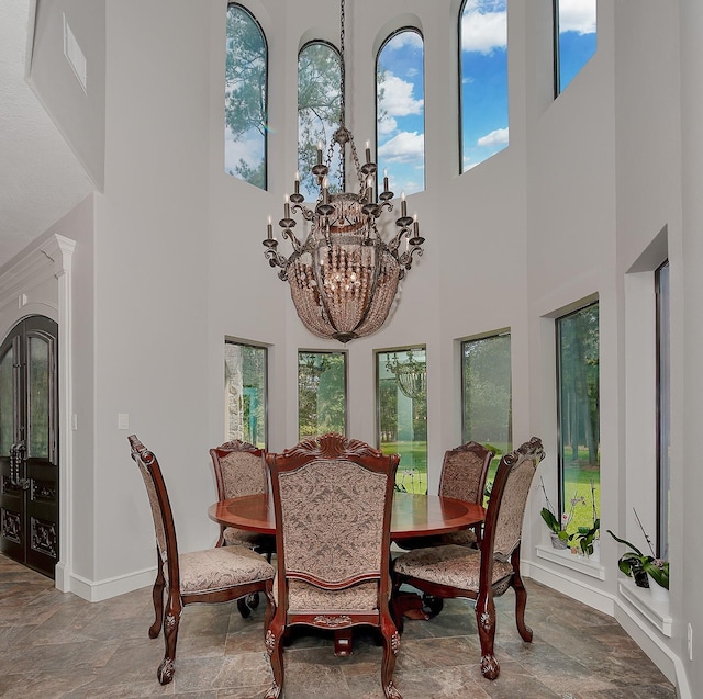 280 Sundog Rd, Huntsville, TX 77340 - dining room featuring a high ceiling, stone finish flooring, a chandelier, and baseboards