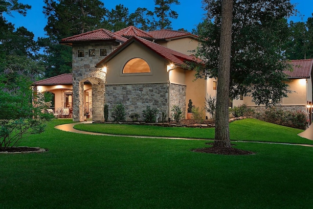 280 Sundog Rd, Huntsville, TX 77340 - mediterranean / spanish-style house featuring stucco siding, stone siding, a front yard, and a tiled roof
