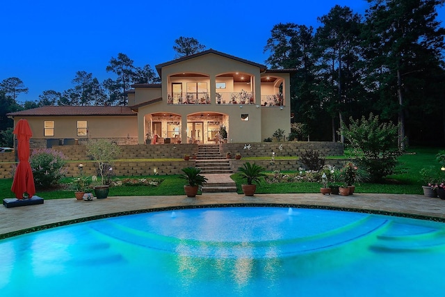 280 Sundog Rd, Huntsville, TX 77340 - back of property with stucco siding, a balcony, stairs, and an outdoor pool