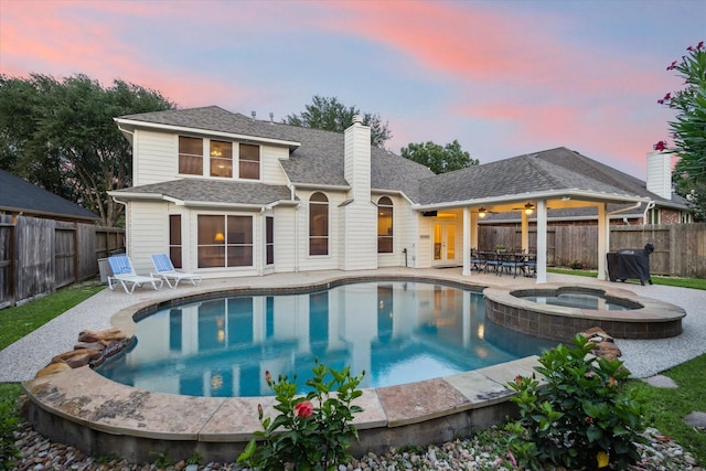 17815 Fairgrove Park Dr, Houston, TX 77095 - back of property featuring a patio area, a fenced backyard, a chimney, roof with shingles, and a pool with connected hot tub